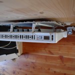 Radiateur électrique décalé du mur avec une feuille de papier aluminium pour réfléchir la chaleur.